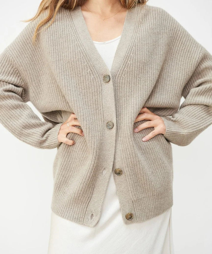 Front view of a soft, stylish women's cashmere cardigan in beige, showcasing its elegant, timeless silhouette for layering.