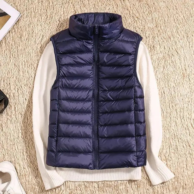 "Ultra-light women's autumn down vest in sleek fit, available in Black, Blue, Khaki; stylish and packable for cool days."