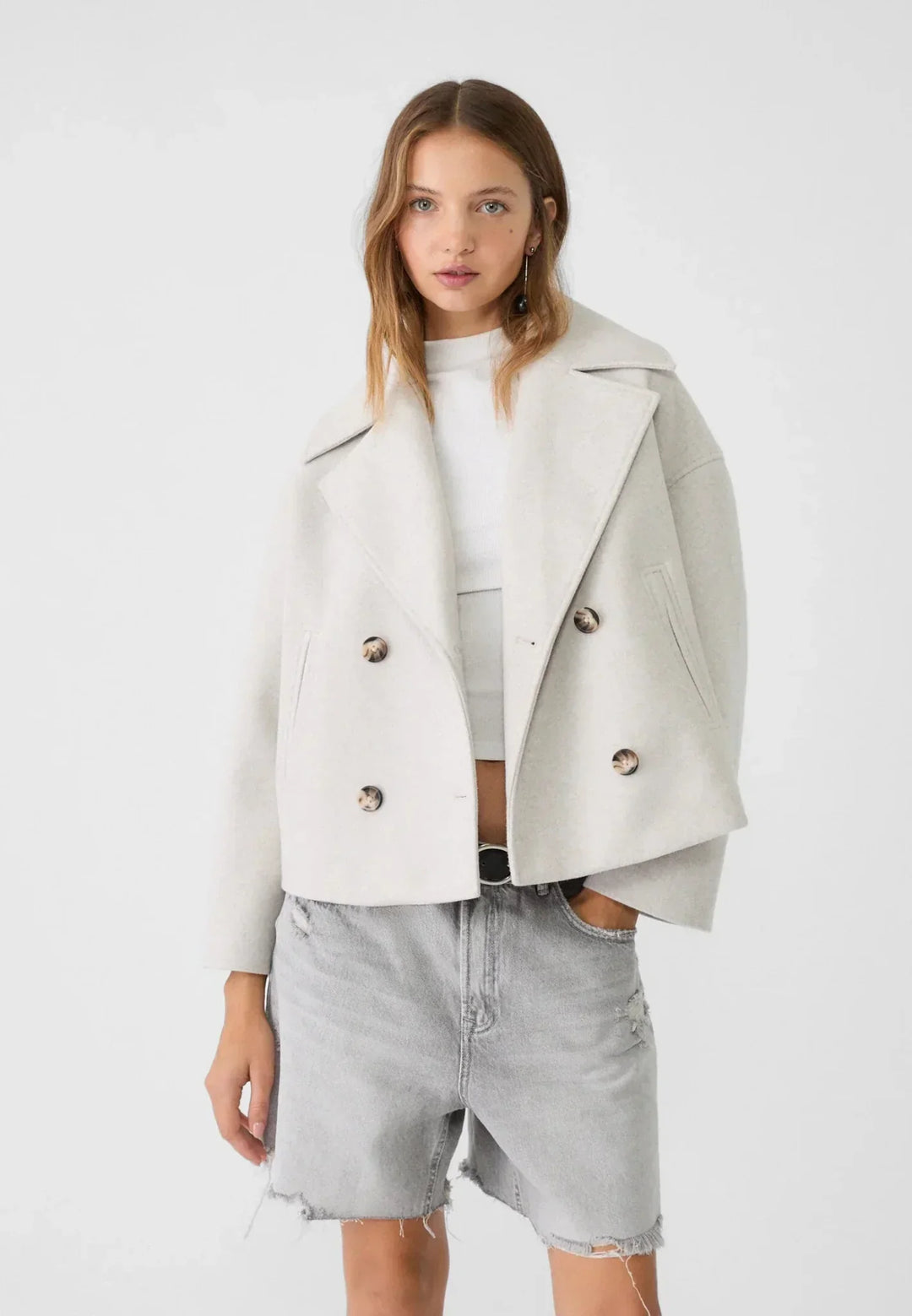 Women's double-breasted cropped jacket, front view featuring sharp lapels, structured design, and chic oversized buttons.
