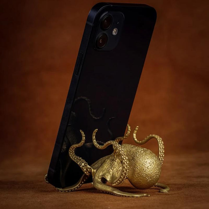 Close-up of a brass octopus phone stand, showcasing intricate design for desktop decor