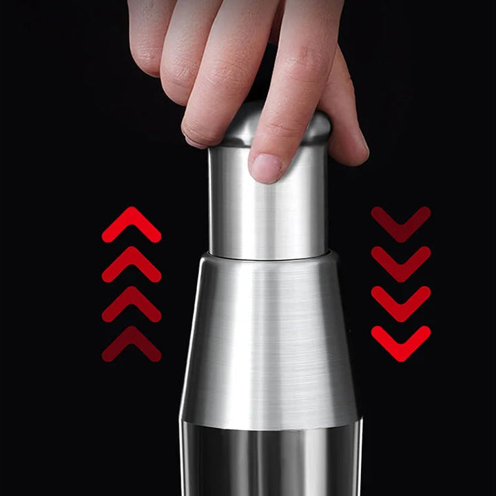 Hand holding a sleek stainless steel garlic chopper for easy food prep