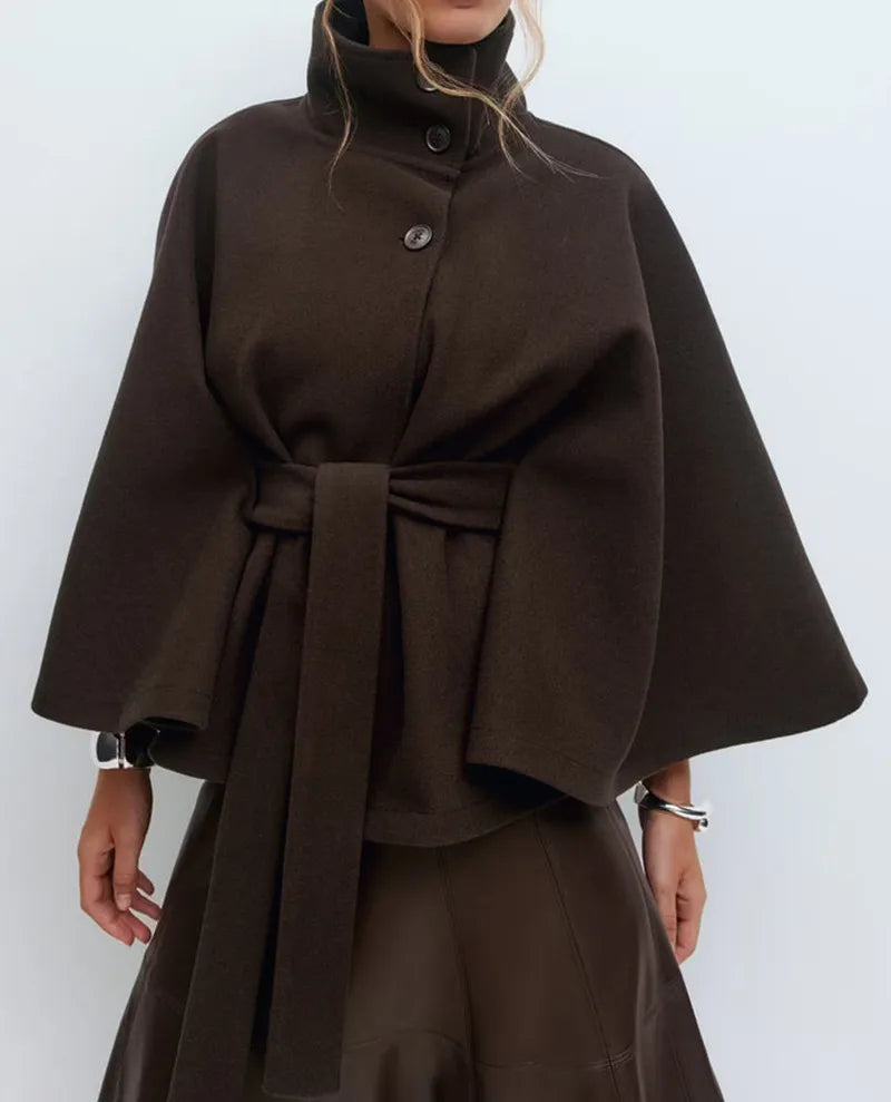 Close-up of the high-neck detail on a women's spring cape coat, featuring a stylish belt.