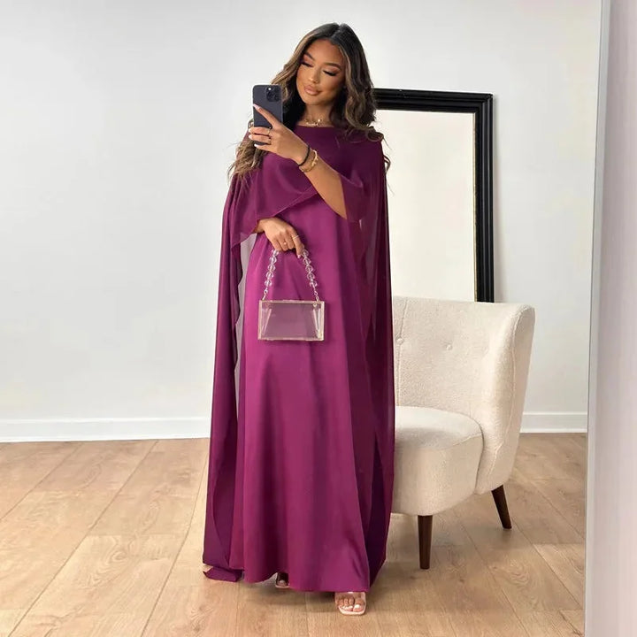Sophisticated women's caped maxi dress in a rich color, suitable for formal gatherings and celebrations.