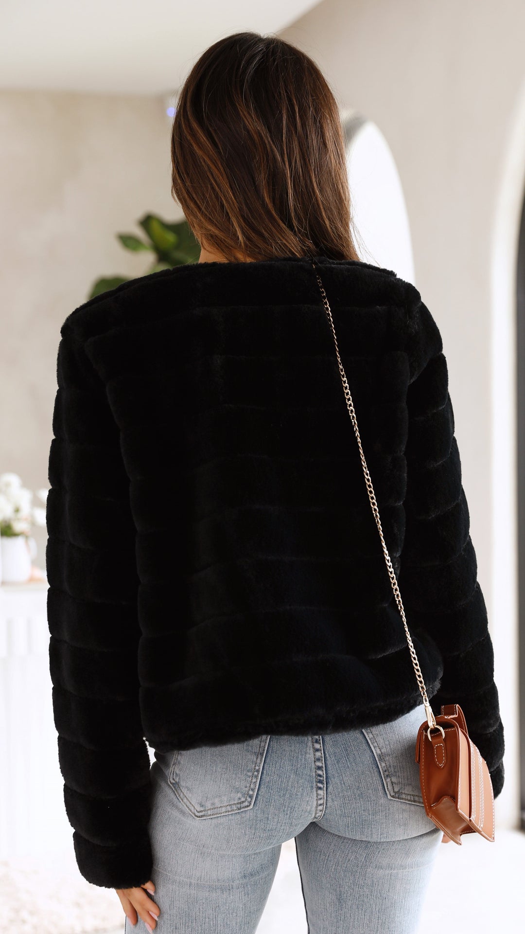 Detail of the collar on a women's fashionable faux fur cropped evening jacket.