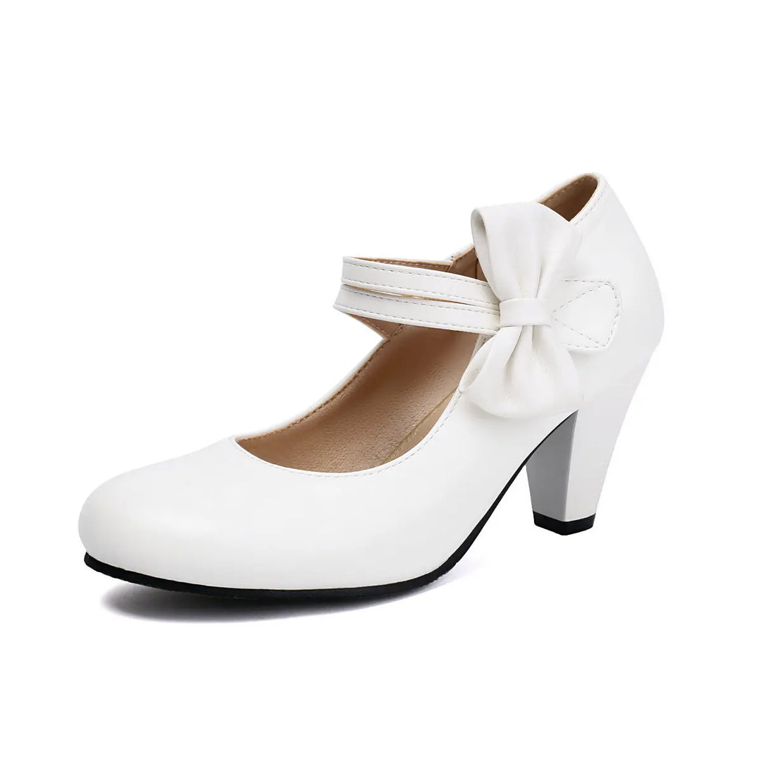 Detailed shot of the block heel and bow on an elegant women's pump, emphasizing quality.