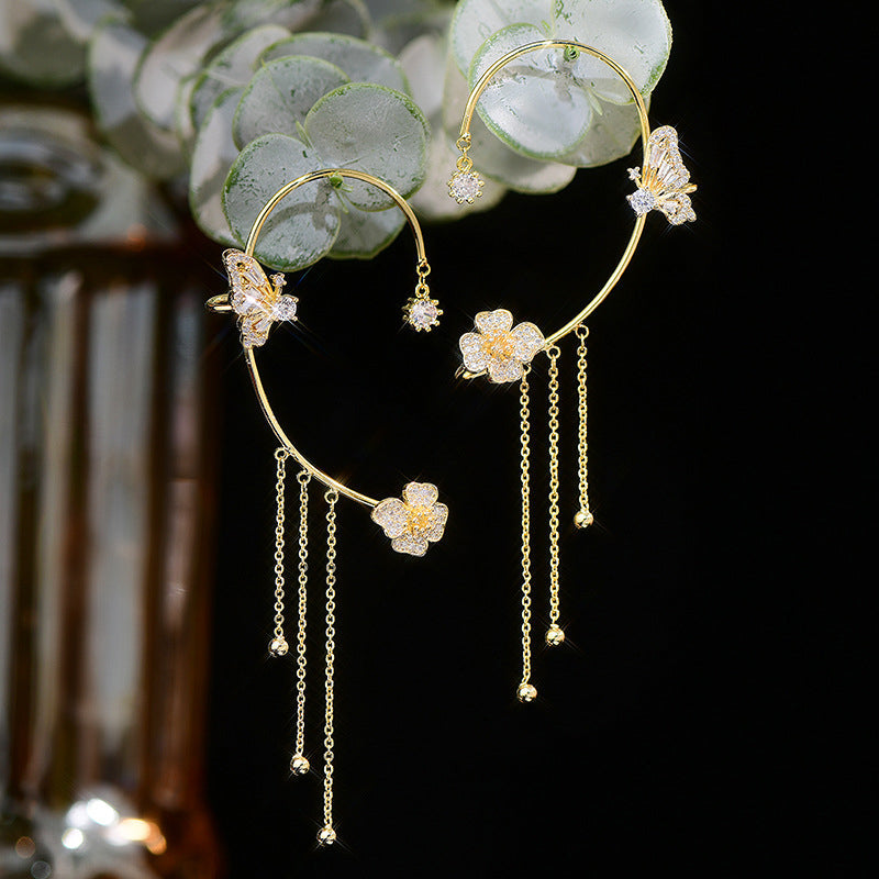 Detailed view of women's party earrings: zircon butterflies and flowing tassels.