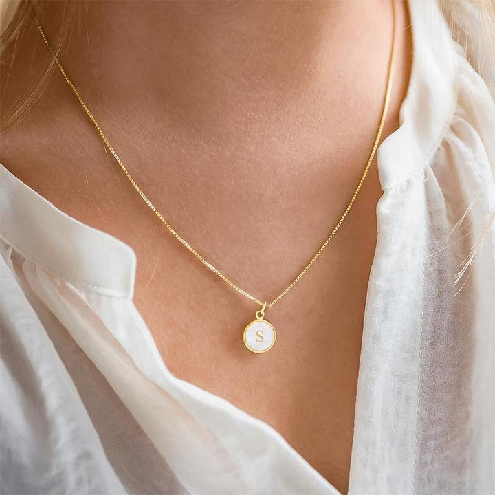 Alphabet necklace featuring a polished round shell pendant with 'M' initial, delicate gold jewelry, unique gift for her