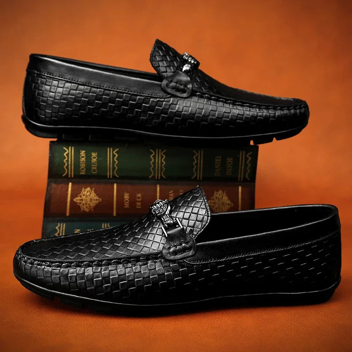 A single black men's grip loafer, displaying its comfortable and elegant dress shoe appeal