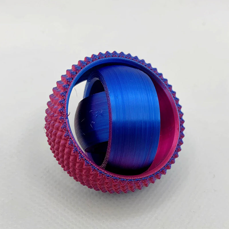 Hand holding the Unisex 3D Concentric Ring Fidget Ball, showing its compact size