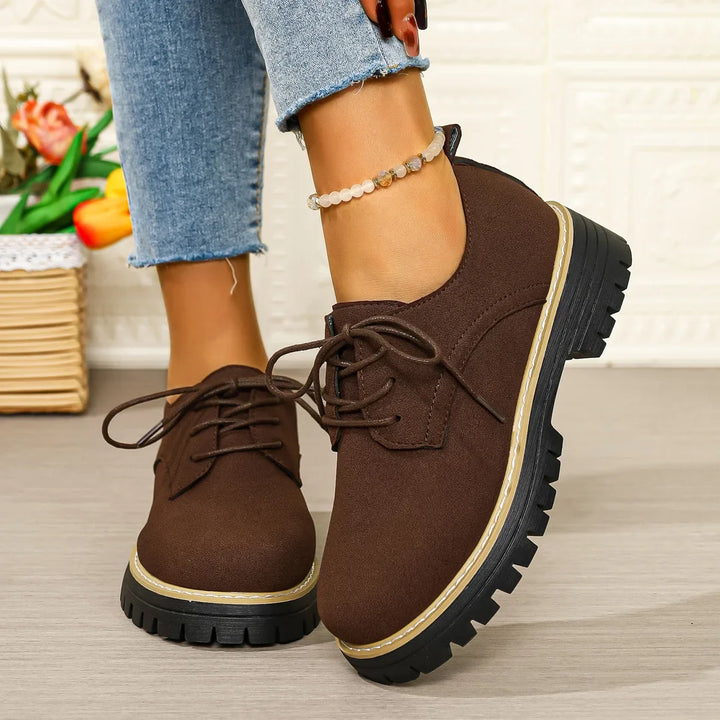 Women's black lace-up platform shoes with a suede finish and chunky sole, perfect for casual wear.