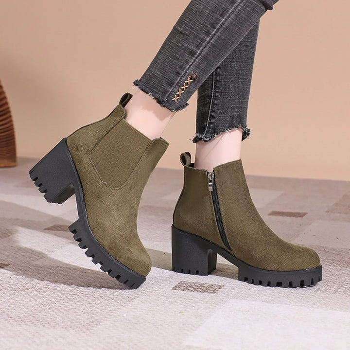 Close-up of a women's gray suede ankle boot featuring a practical and comfortable block heel