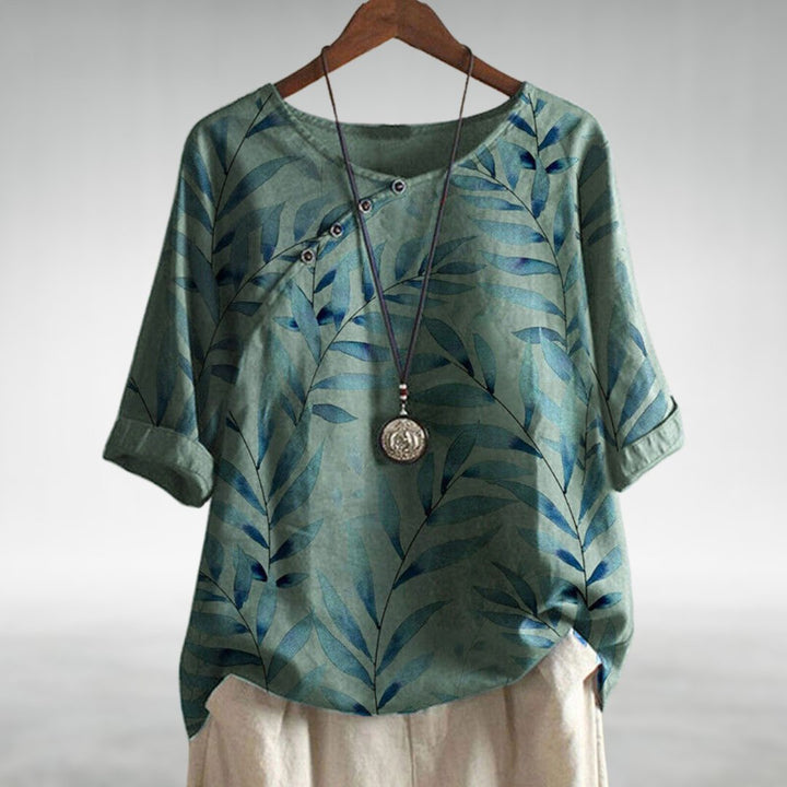 Printed women's button-up top with a vibrant leaf pattern, suitable for casual summer outfits