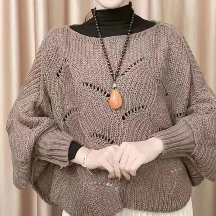Model wearing a fashionable women's batwing knit shawl sweater in a neutral tone