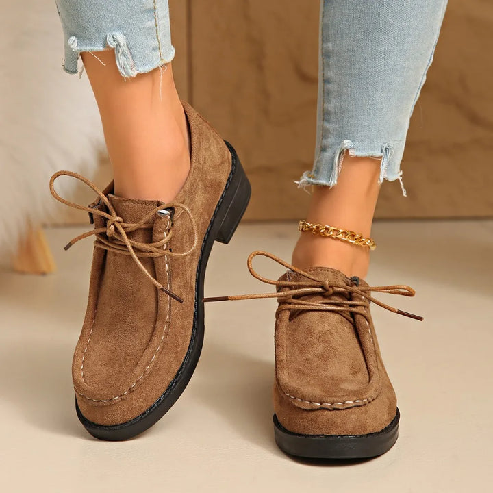 Model wearing women's comfortable loafers with arch support, styled with casual trousers