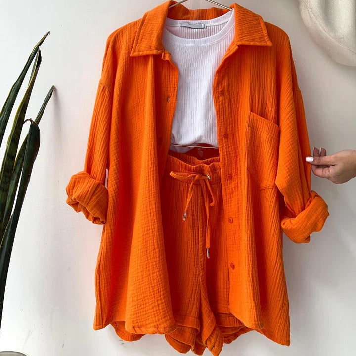 Women's crinkle lounge set in coral, featuring a button-up top and drawstring shorts for summer comfort.