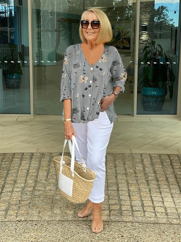 Beautiful women's floral print blouse featuring a button-front, V-neck, & chic three-quarter sleeves.
