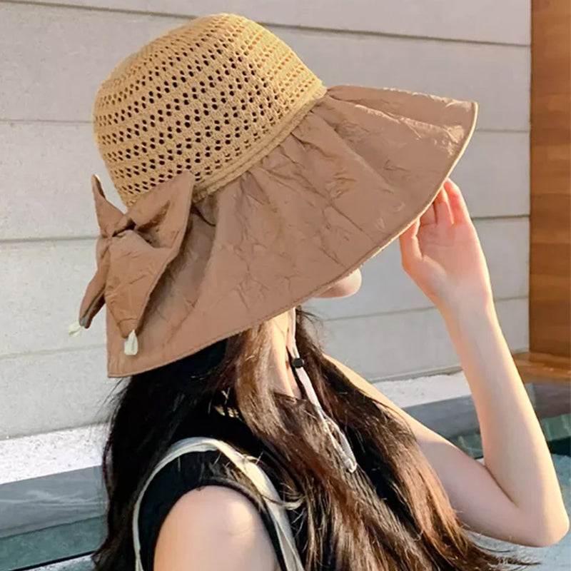 A neatly folded women's wide-brim sun hat with a bow, demonstrating its travel convenience.