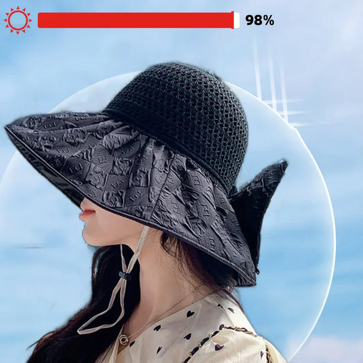 Close-up of a women's foldable wide-brim sun hat texture, showing the papyrus weave and bow.