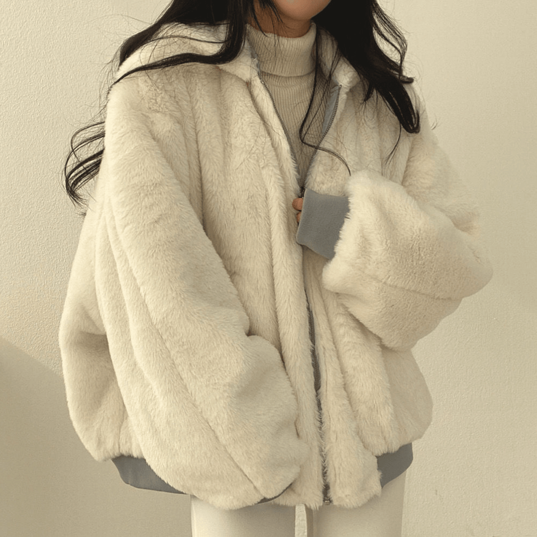 Stylish women's relaxed fit winter jacket, olive green, paired with jeans and boots.